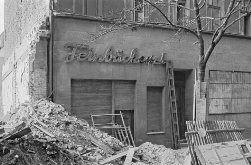 Fading lettering in the entrance area and shop window of a retail store 'Feinbaeckerei' in the demolition street area of an old residential building facade on Colbestrasse in the district of Friedrichshain in Berlin East Berlin in the area of the former GDR, German Democratic Republic