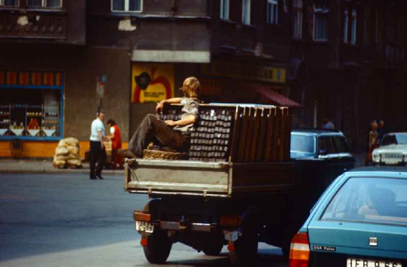 Worker - coal carrier Coal carrier on the loading area of a small truck with baskets full of coal in the Mitte district of East Berlin in the territory of the former GDR, German Democratic Republic