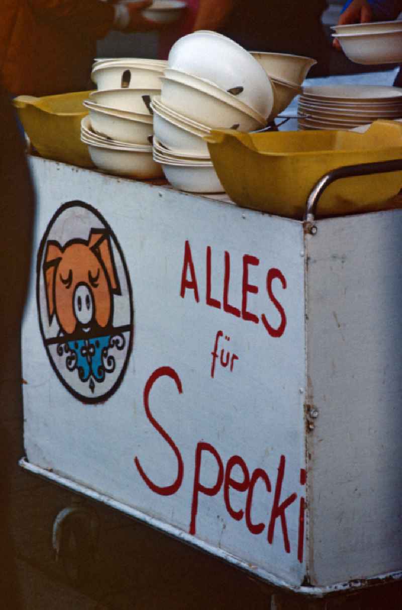 Stand selling stew from the youth center at Alexanderplatz in East Berlin in the area of the former GDR, German Democratic Republic. Bin for leftover food, labeled 'Everything for Specki' and a drawing of a pig
