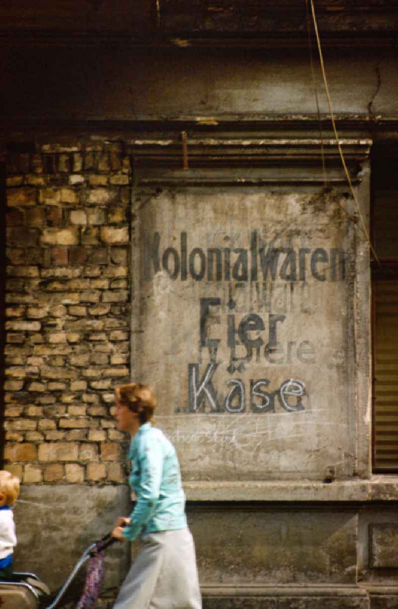Terms Colonial goods, eggs, beers and cheese on a house wall in East Berlin in the territory of the former GDR, German Democratic Republic