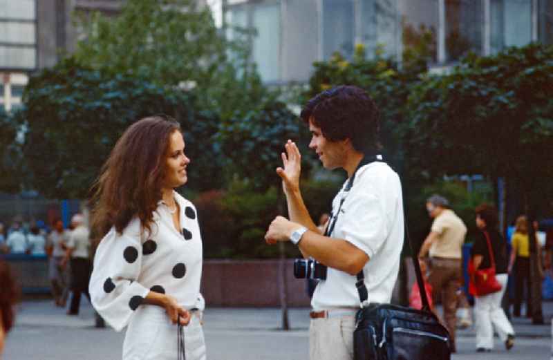Photographer talking to a young woman on Alexanderplatz in East Berlin in the territory of the former GDR, German Democratic Republic