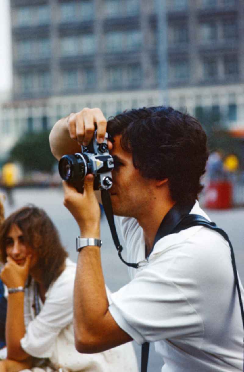 Man takes photographs on Alexanderplatz in East Berlin on the territory of the former GDR, German Democratic Republic