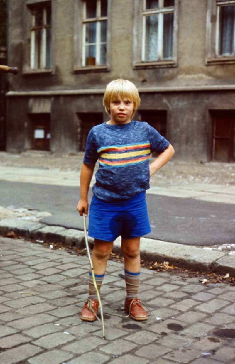Boy with wet pants in East Berlin on the territory of the former GDR, German Democratic Republic