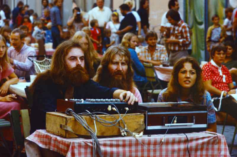 People at the Pankefest in Berlin, East Berlin, in the area of the former GDR, German Democratic Republic. Participants sit in front of a mixing desk