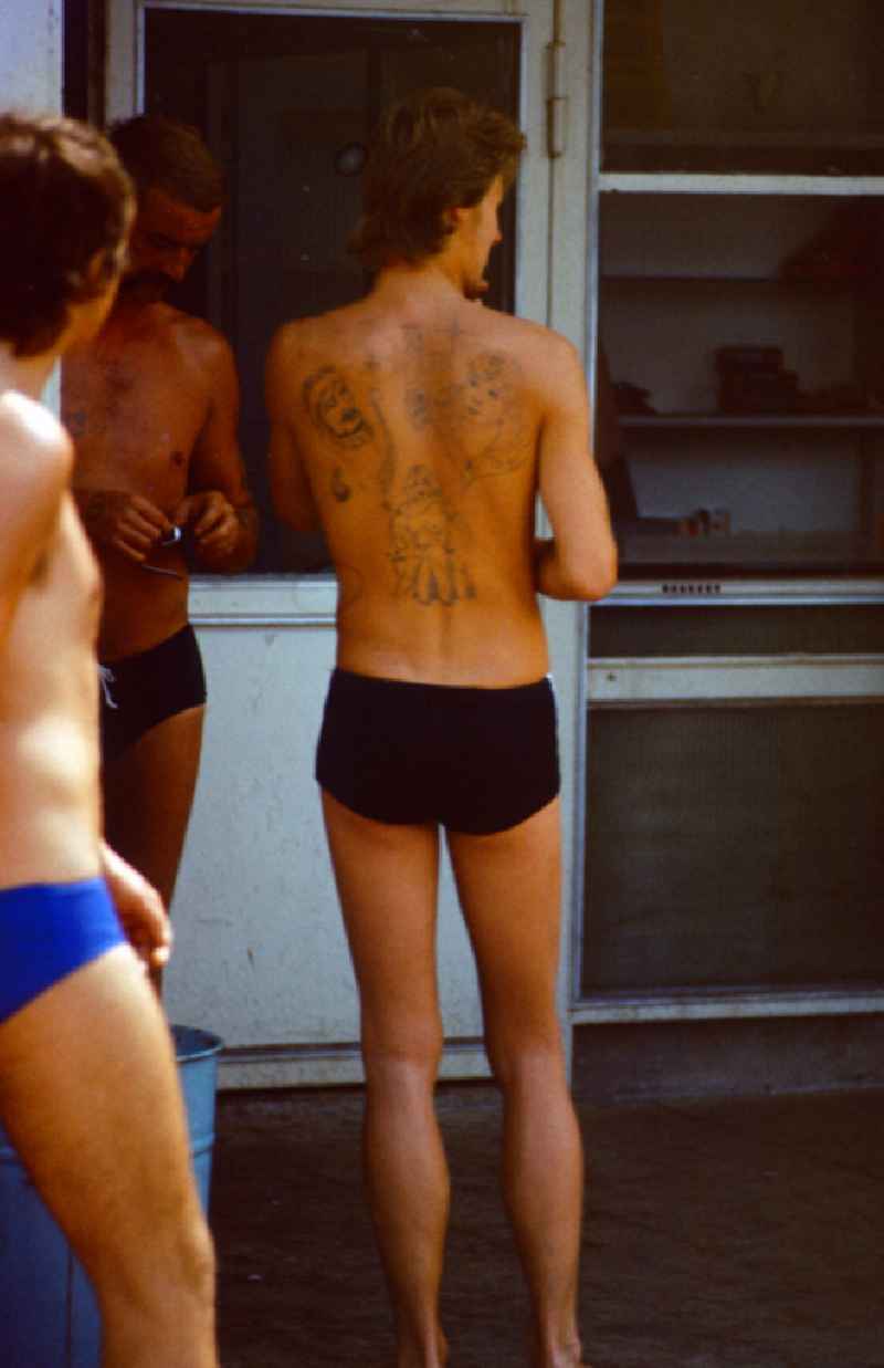 Man with tattoos on his back in the Pankow outdoor swimming pool in East Berlin on the territory of the former GDR, German Democratic Republic