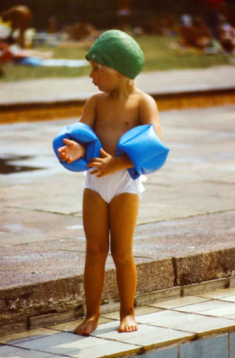 Child with swimming cap and water wings in the Pankow outdoor swimming pool in East Berlin on the territory of the former GDR, German Democratic Republic