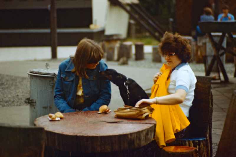 Women eat a Bockwurst in East Berlin on the territory of the former GDR, German Democratic Republic