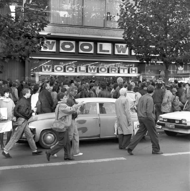 Rush to a 'WOOLWORTH' branch on the Kurfürstendamm in Berlin shortly after the wall came down. Likewise, vehicles dominate the GDR as Trabent and Wartburg the streets in West Berlin