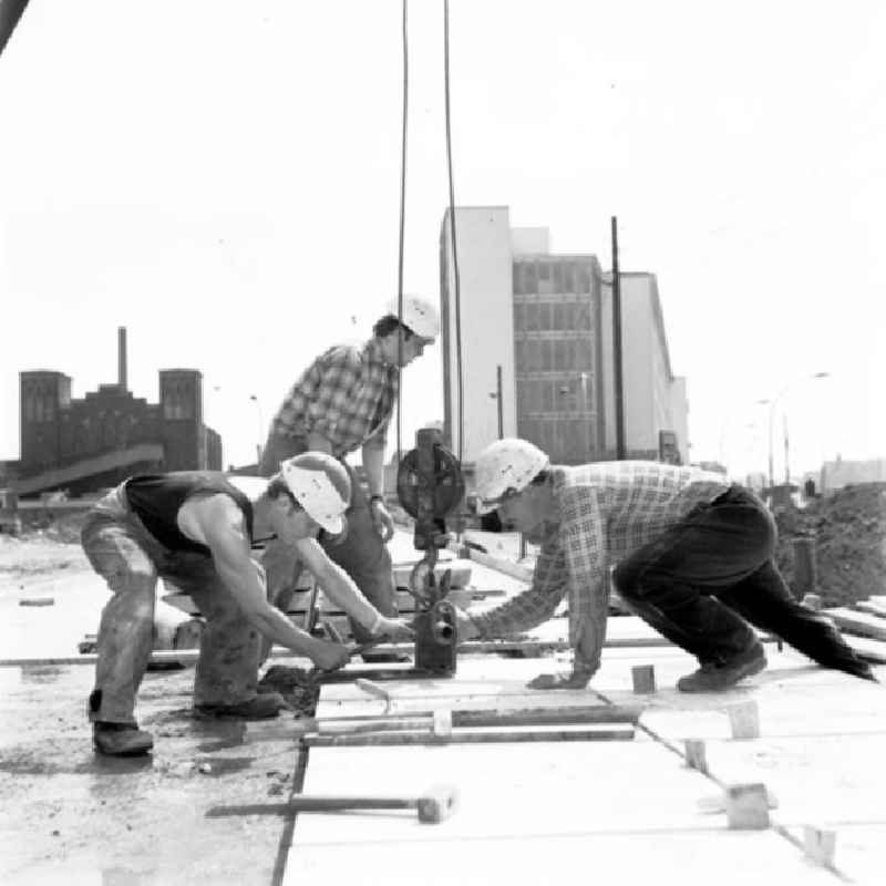 Bauarbeiten auf dem Vorplatz vom Ostbahnhof. Betonarbeiter der Brigade Nitz beim Platten verlegen.