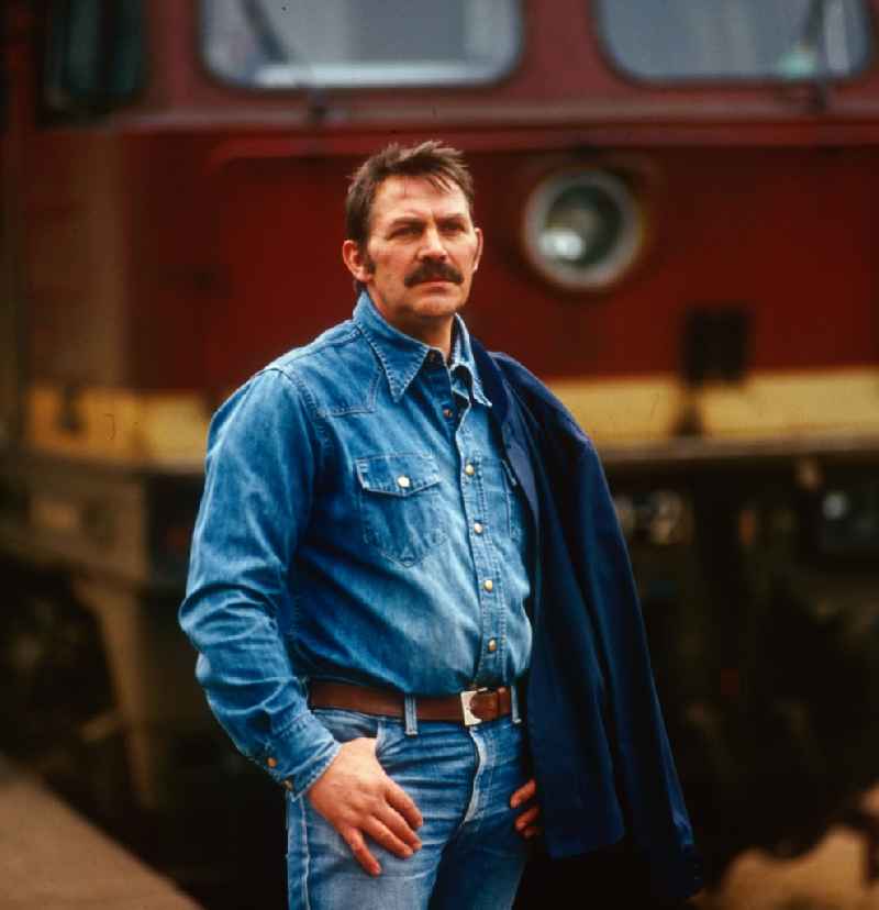 East German actor, director and writer Ulrich Thein in front of a locomotive V 20