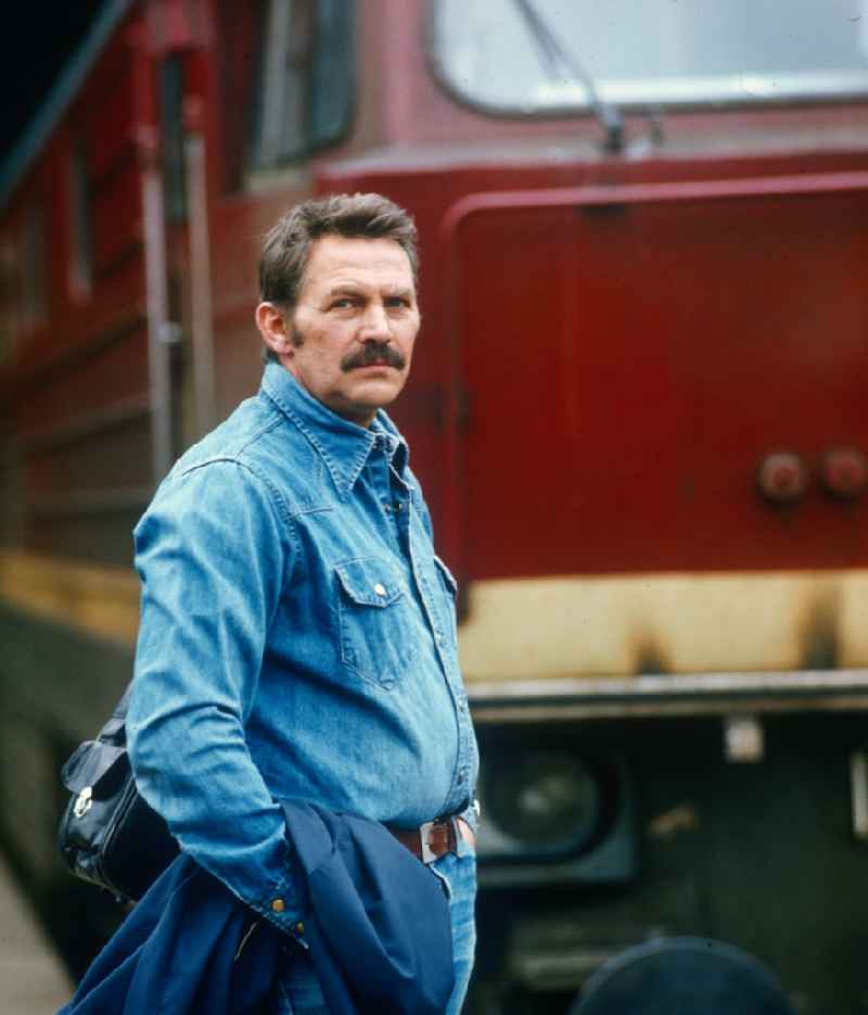 East German actor, director and writer Ulrich Thein in front of a locomotive V 20