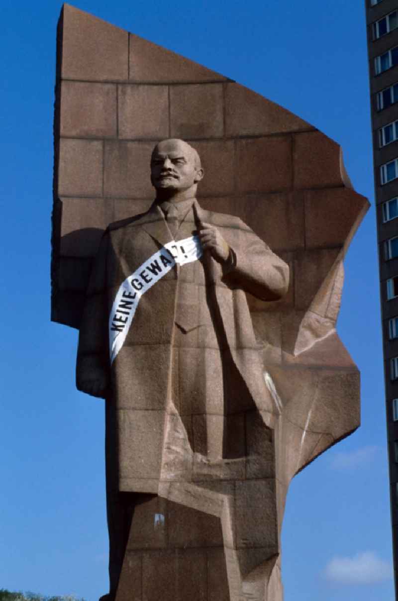 The Lenin monument of red granite with banner 'No violence!' in Berlin - Friedrichshain. The Lenin monument stood since 1979 on the monument list the GDR and was demolished in 1991