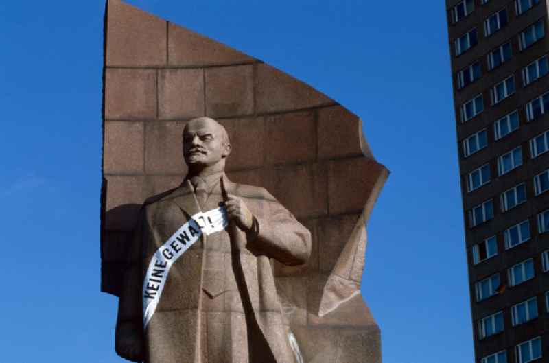 The Lenin monument of red granite with banner 'No violence!' in Berlin - Friedrichshain. The Lenin monument stood since 1979 on the monument list the GDR and was demolished in 1991