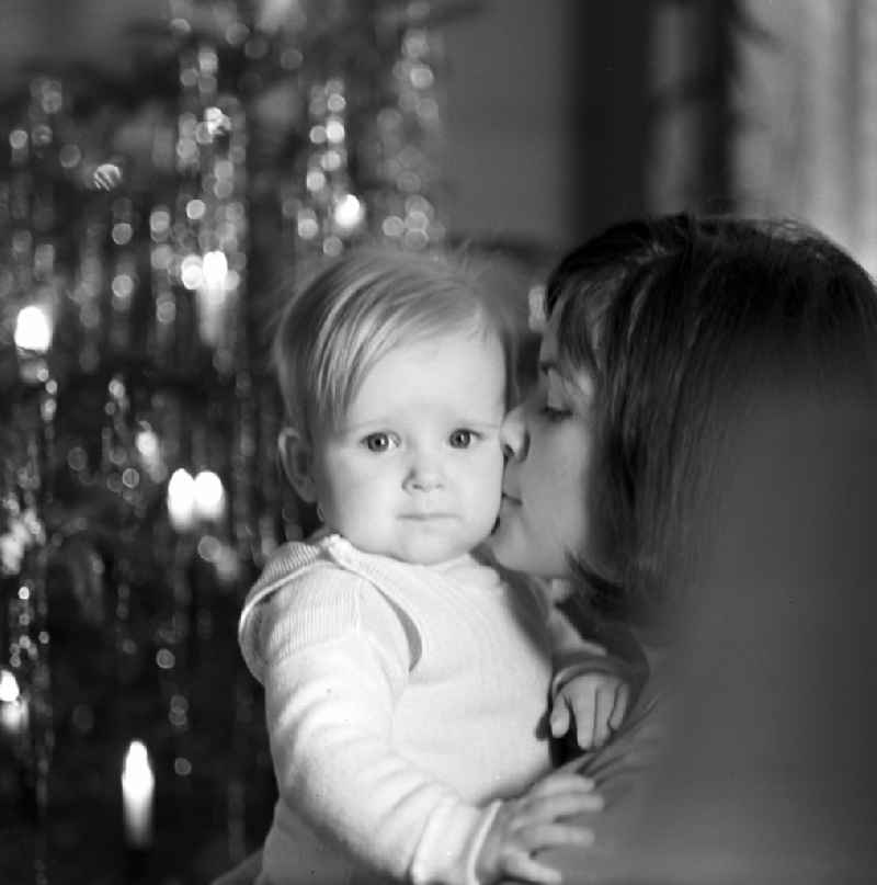 Mother with baby in her arms in front of a Christmas tree in Berlin - Friedrichshain