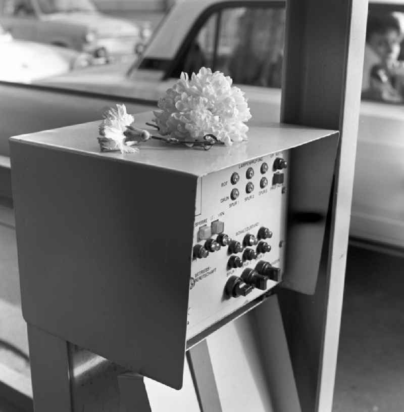 Flowers lying on a cabinet with control switch for barriers and security devices at the border crossing at Heinrich-Heine-Straße in Berlin - Friedrichshain