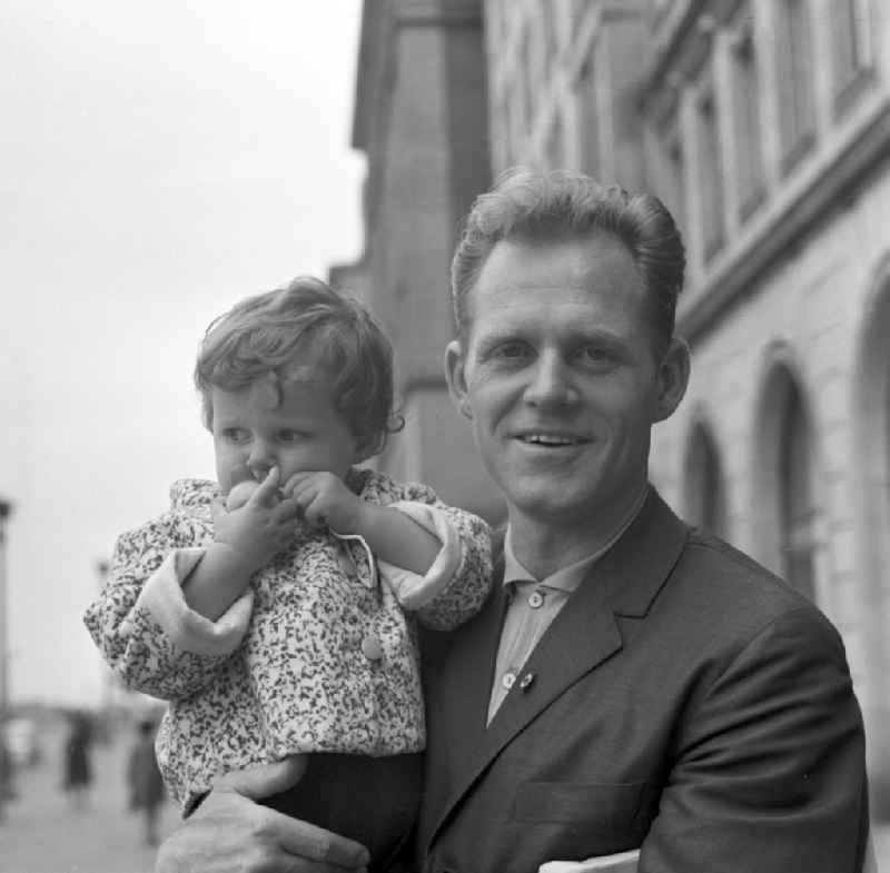 Gustav-Adolf 'Täve' Schur with a small child in her arms, Berlin. He is a former German cyclist and was the most popular athletes in the GDR