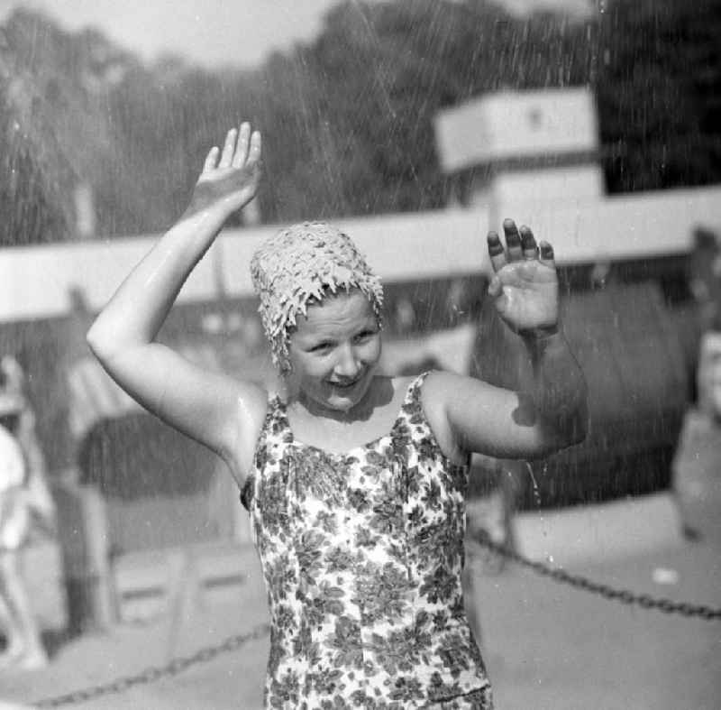 A woman in swimsuit with swimming cap in the shower in the beach Müggelsee in Berlin - Köpenick. The lido Müggelsee, also known as beach Rahn village is a swimming pool in Berlin-Rahn village on the north bank of the Müggelsee
