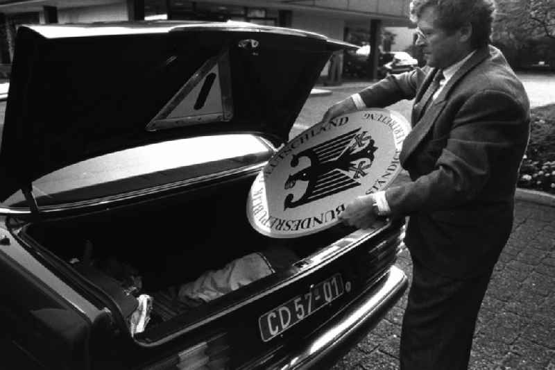 Demontage vom Vertretungsschild der BRD (Ständige Vertretung) in der Hannoverschen Strasse. Mann legt das Schild in den Kofferraum eines Mercedes-Benz.