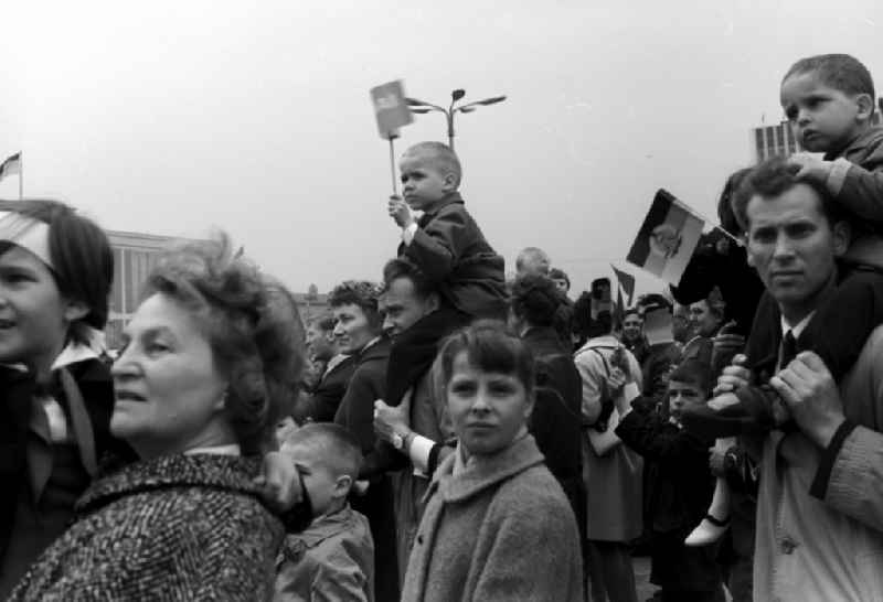Enthusiastic GDR citizens with children and family while parading on the rostrum as the anniversary of the first On May Schlossplatz in Berlin - Mitte
