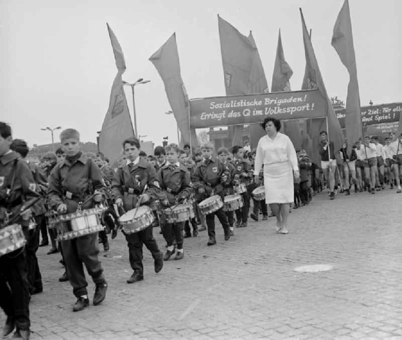 Enthusiastic GDR citizens with children and family while parading on the rostrum as the anniversary of the first On May Schlossplatz in Berlin - Mitte