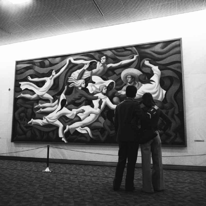 A soldier of the NVA viewed with girlfriend the painting 'World Youth song' by Lothar Zitzmann in the Palace of the Republic in Berlin - Mitte. The image idea is the World Youth song based