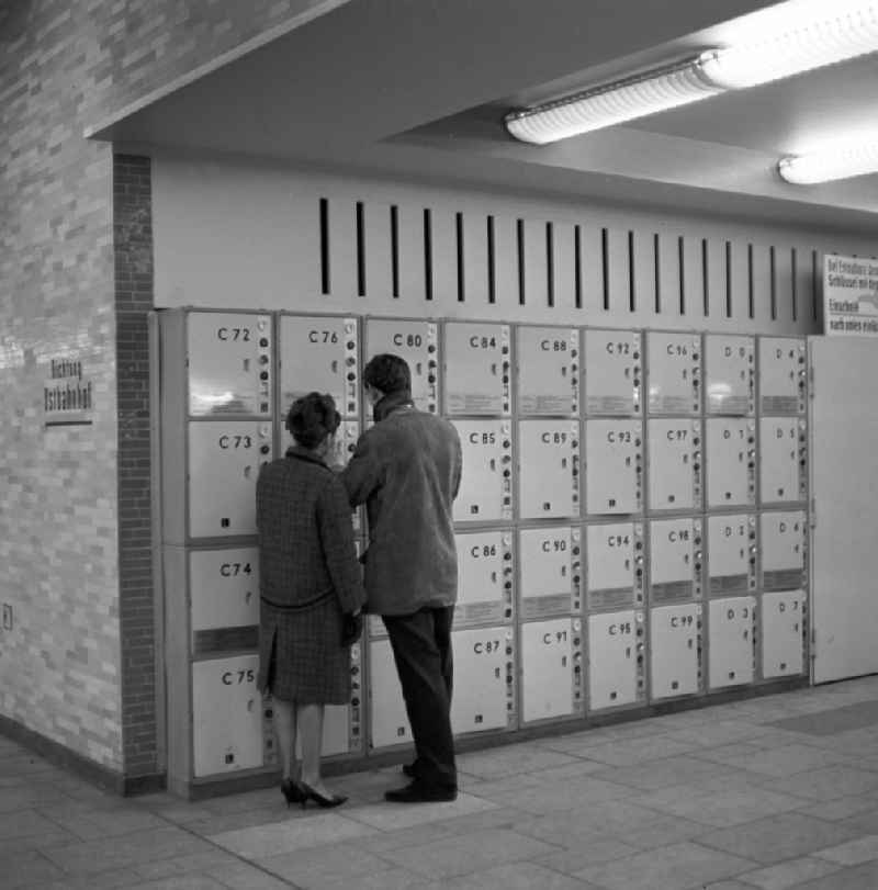 A young couple standing in front of lockers at Alexanderplatz station in Berlin - Mitte