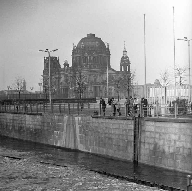 Anglers are on the Spree canal at Palace Square, once Marx-Engels-Platz, in Berlin - Mitte. In the background of the Berlin cathedral is seen
