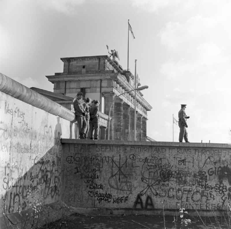 DDR-Grenzsoldaten auf der Mauer vor dem Brandenburger Tor in Berlin.