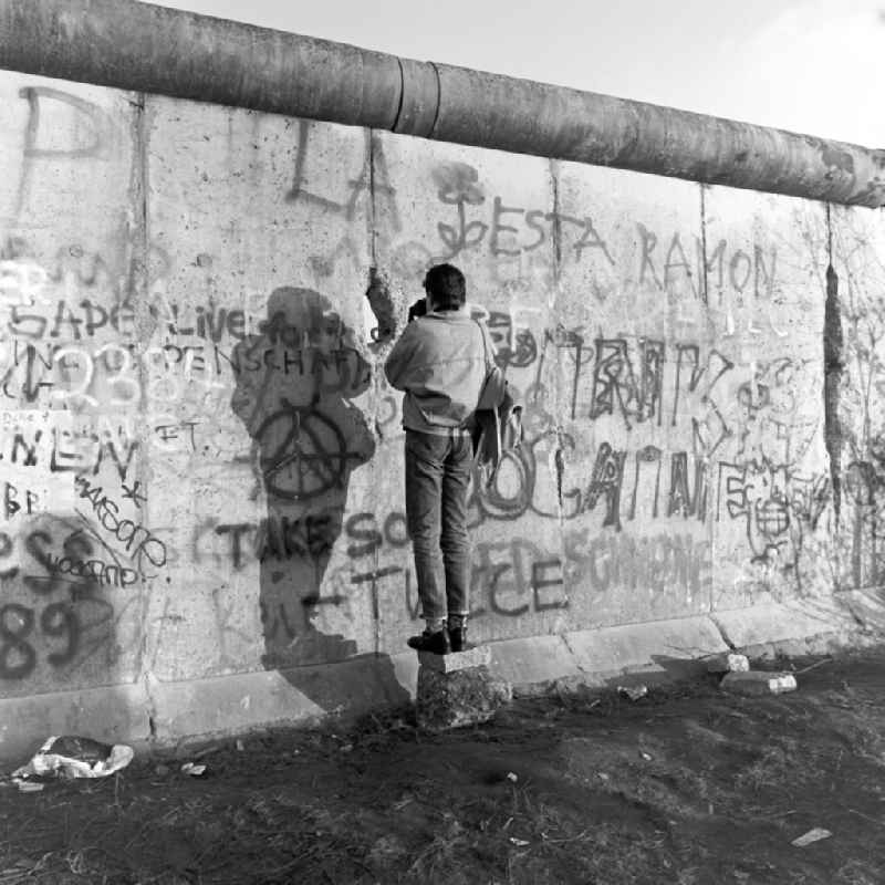 A man photographs through a crack in the Berlin Wall in Berlin