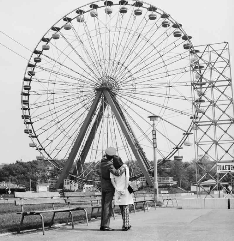 A soldier of the NVA with his wife to visit the Cultural Park Plänterwald in Berlin - Treptow. A special attraction was the Ferris wheel with 36 gondolas that extends 45 meters into the air. The amusement park was opened in 1969. From 1990 to 20