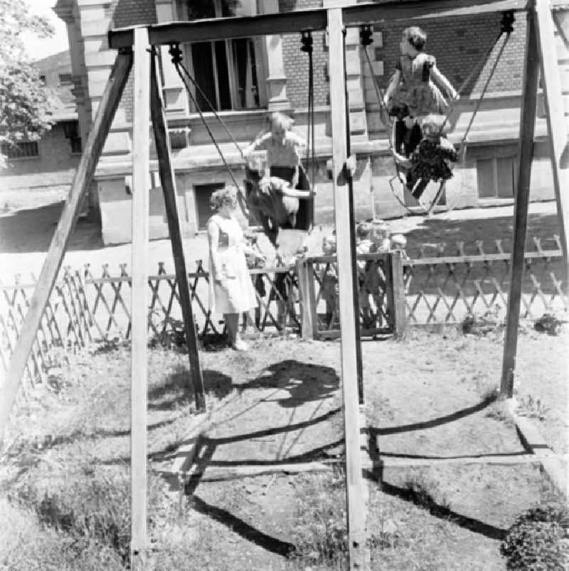 Kinder / Kleinkinder schaukeln (Schaukel) auf Kindergarten-Spielplatz.