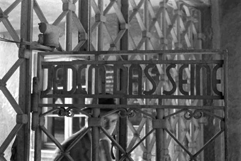 Ein Besucher geht durch das Lagertor des ehemaligen Konzentrationslager Buchenwald mit der Inschrift 'Jedem das Seine'. In den 5