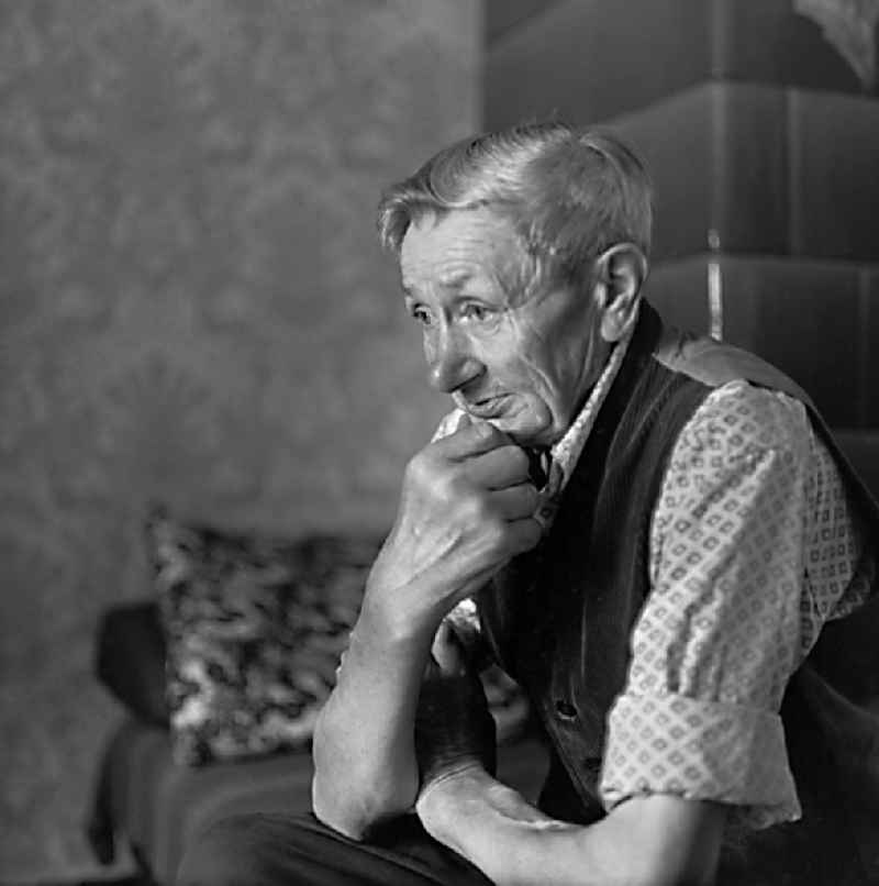 Portrait shot of an old Sorb in front of his tiled stove in Burg (Spreewald), Brandenburg on the territory of the former GDR, German Democratic Republic