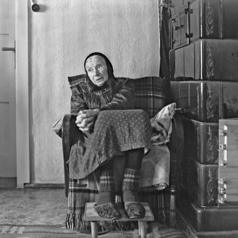 Portrait shot of an old Sorbin with traditional clothing in front of a tiled stove in Burg (Spreewald), Brandenburg in the area of ??the former GDR, German Democratic Republic