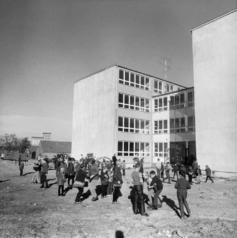 Schulkinder toben in Casekow bei Angermünde auf dem noch nicht fertiggestellten Schulhof. Die neue Schule / POS / Polytechnische Oberschule ist gerade eröffnet worden, ein Jahr zuvor war die alte Schule nach einem Hochwasser unbenutzbar geworden. 1972 folgt noch eine neue Sporthalle.