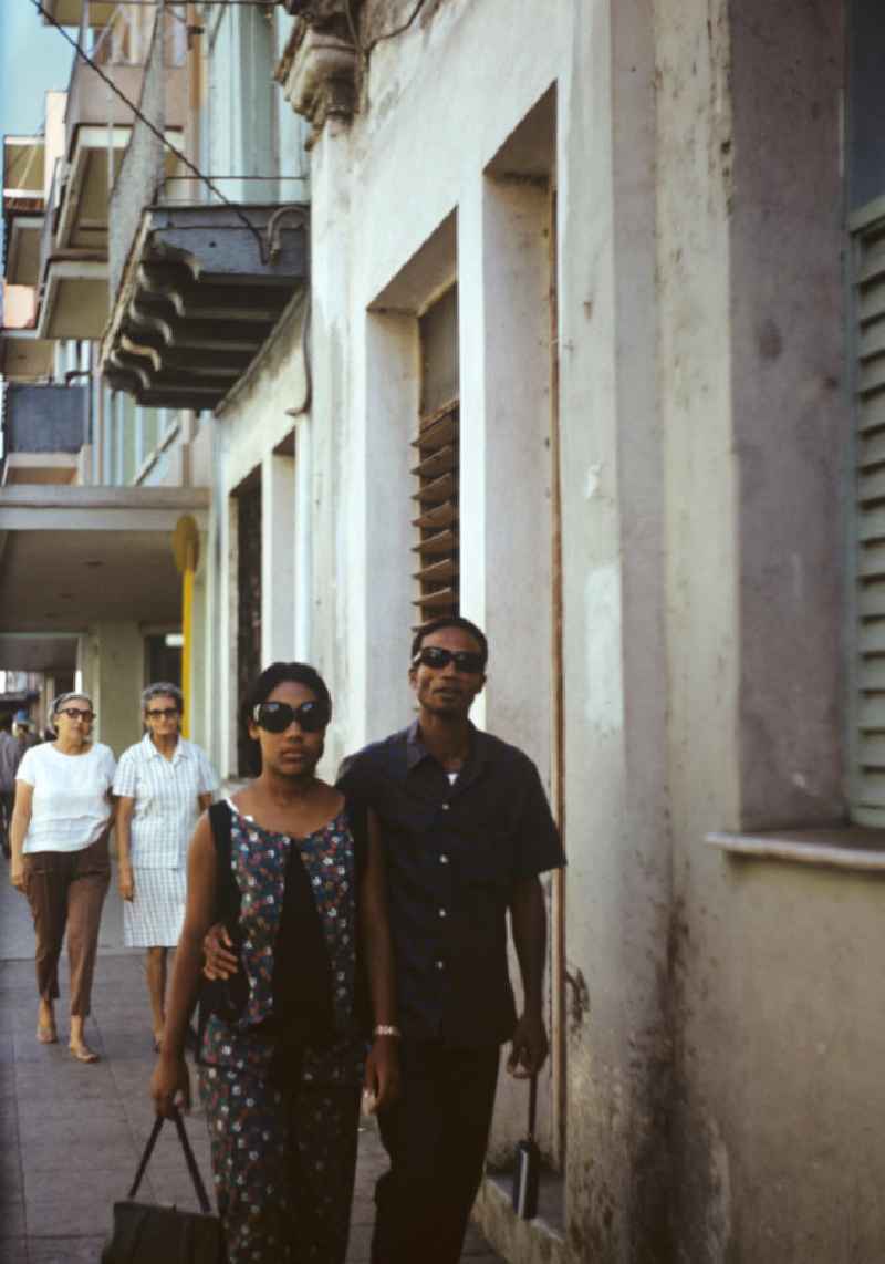 Eine junges Paar läuft durch eine Straße der drittgrößten Stadt Kubas, Camagüey.