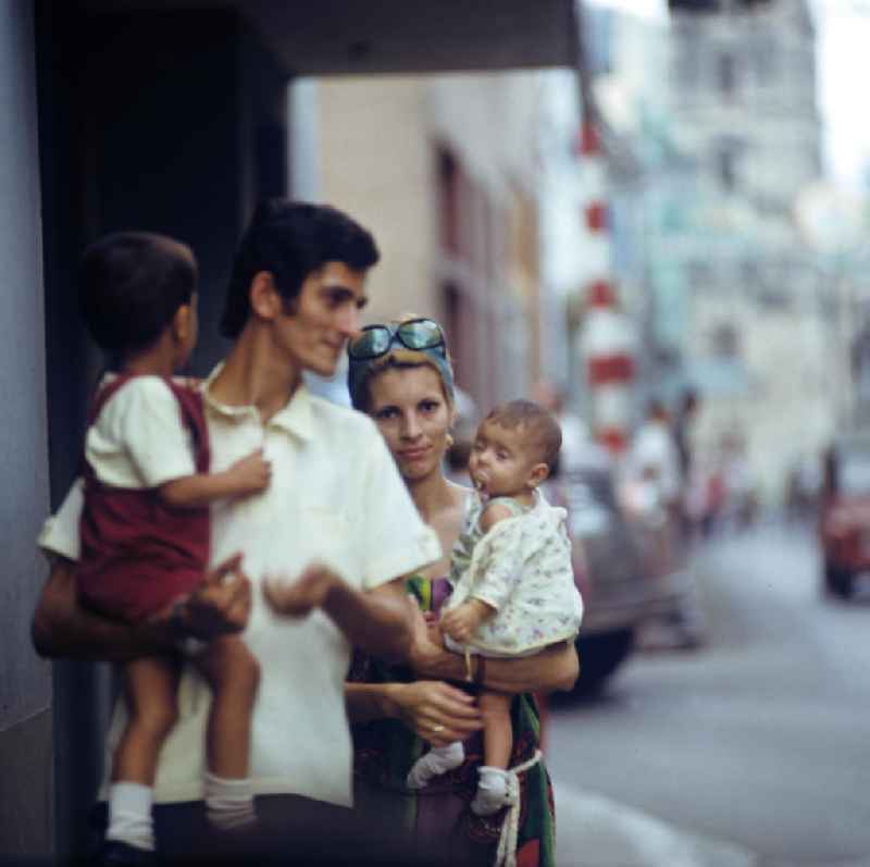 Eine junge Familie läuft durch eine Straße der drittgrößten Stadt Kubas, Camagüey.