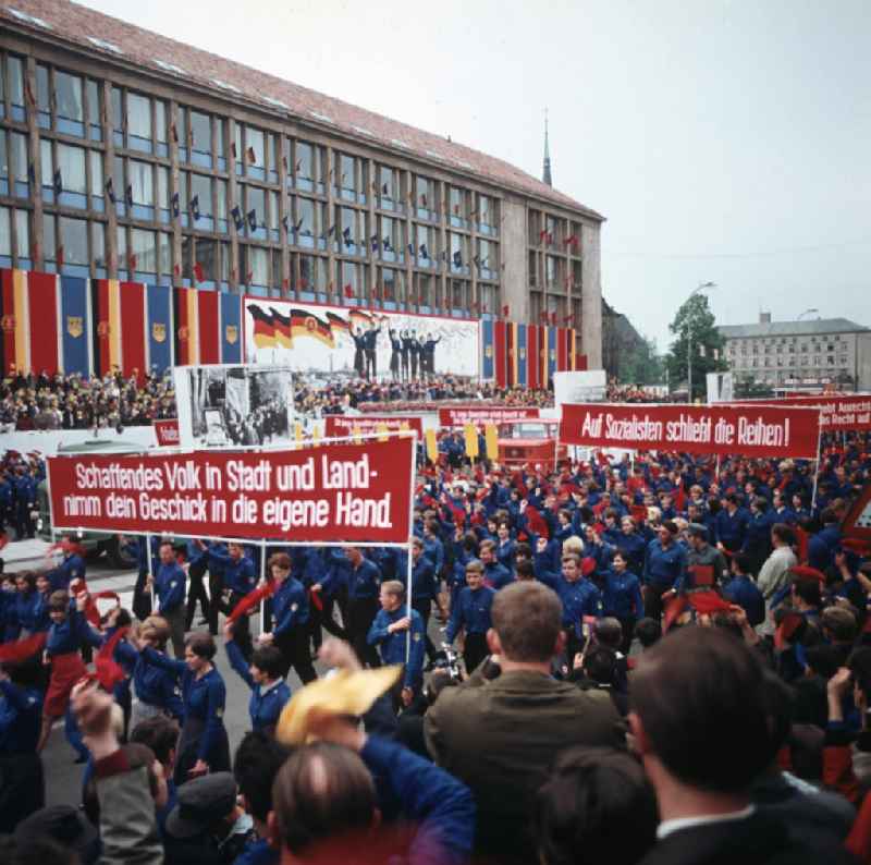 Eine Demonstration der FDJ marschiert während des FDJ-Pfingsttreffens in Karl-Marx-Stadt, heute Chemnitz, auf der Straße der Nationen. Auf den Transparenten sieht man die Losungen 'Schaffendes Volk in Stadt und Land - nimm dein Geschick in die eigene Hand.' und 'Auf Sozialisten schließt die Reihen!'. Bei den alle fünf Jahre stattfindenden Pfingsttreffen kamen Zehntausende delegierte Mitglieder der FDJ aus der ganzen DDR zusammen.