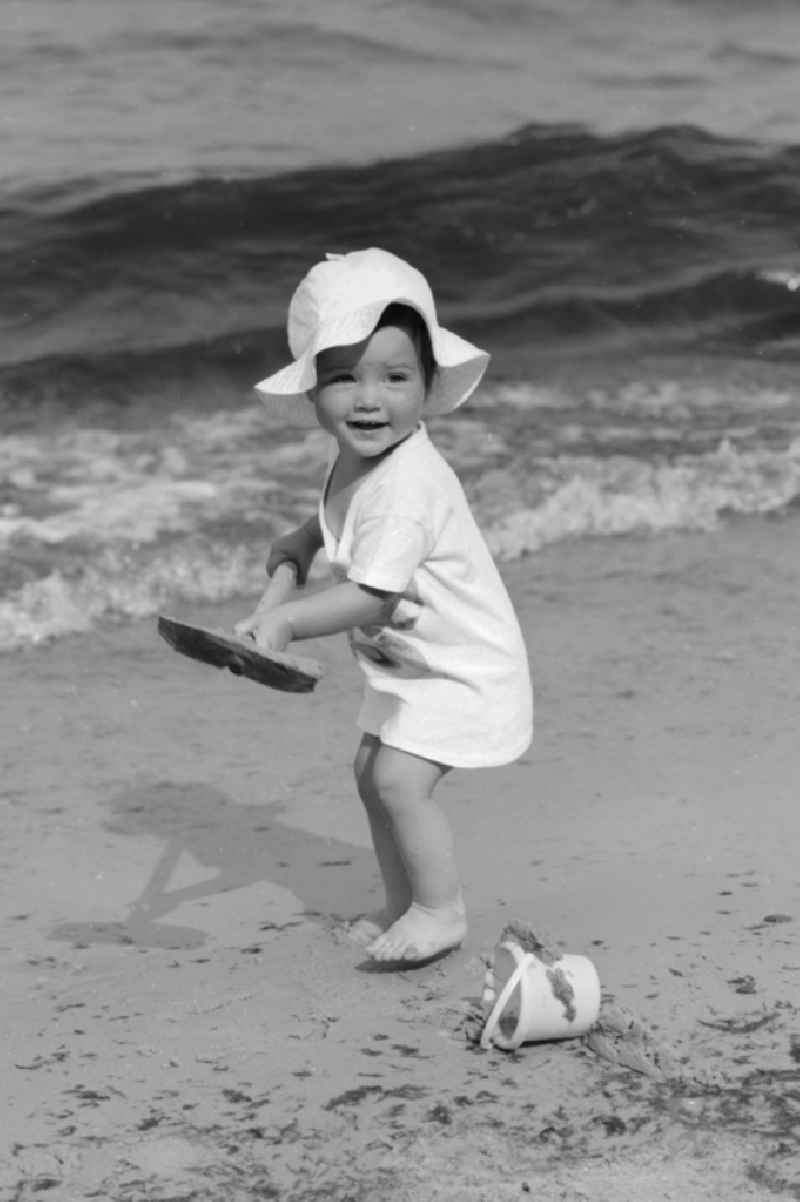 Little child with shovel and pail on the beach in Ueckeritz in Mecklenburg-Western Pomerania in the field of the former GDR, German Democratic Republic