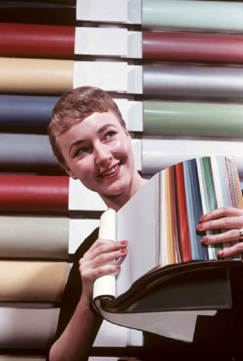A woman presents a color chart for artificial leather from VEB Cowaplast-Werke Coswig in Coswig, Saxony in the territory of the former GDR, German Democratic Republic