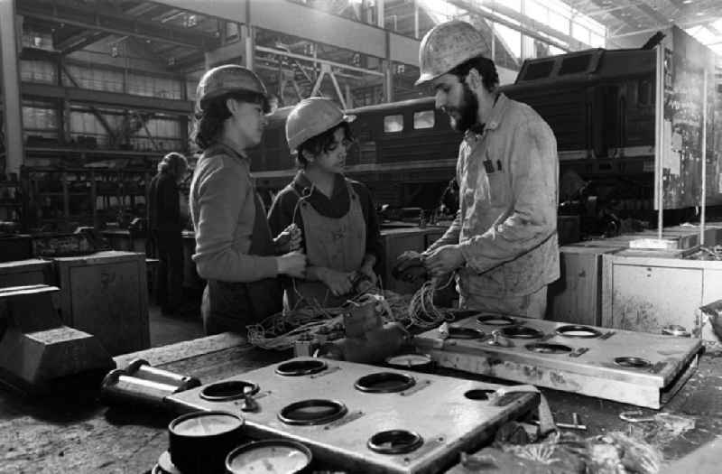 Zwei junge Damen werden von einem Arbeiter im RAW (Reichsbahnausbesserungswerk) Cottbus eingewiesen. Im Rahmen des polytechnischen Unterricht nahmen die Schüler aktiv an der DDR-Produktion teil.