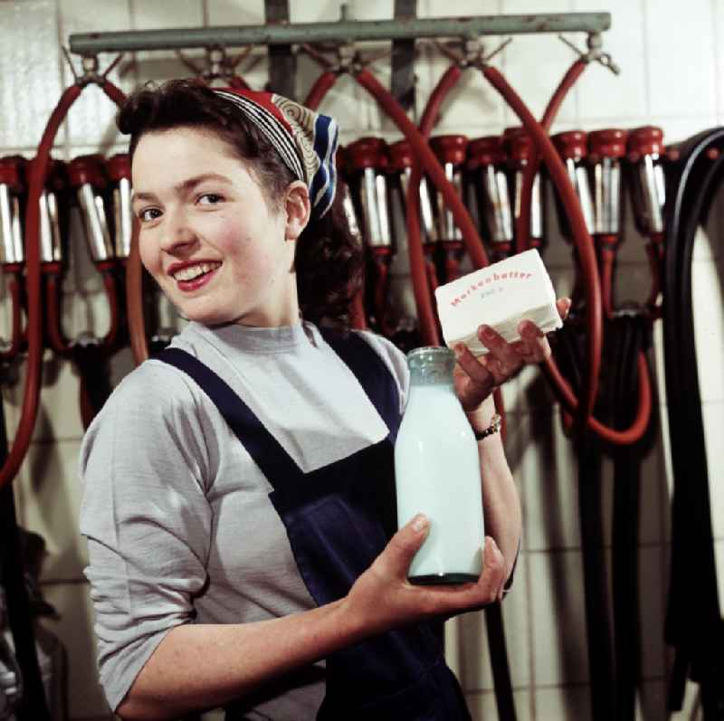A young milkmaid of a Saxon agricultural production cooperative (LPG) presents milk in glass bottles in Doebeln, Saxony in the territory of the former GDR, German Democratic Republic