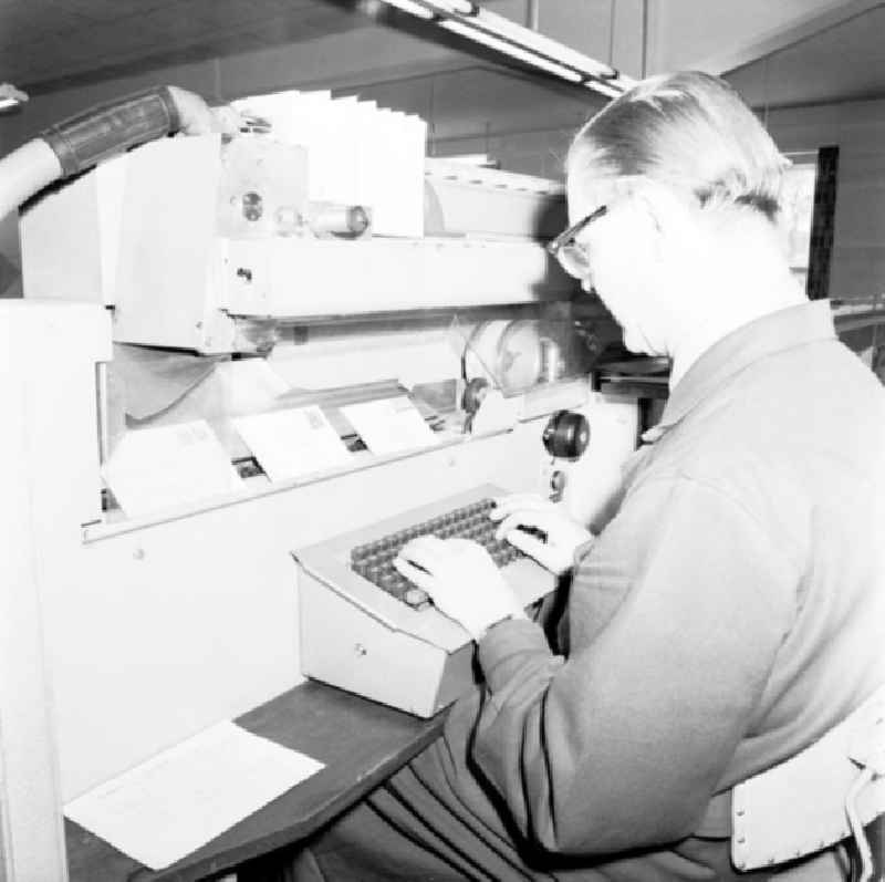 Blick in das Briefzentrum Dresden. Mitarbeiter sitzt an Brief-Sortiermaschine.