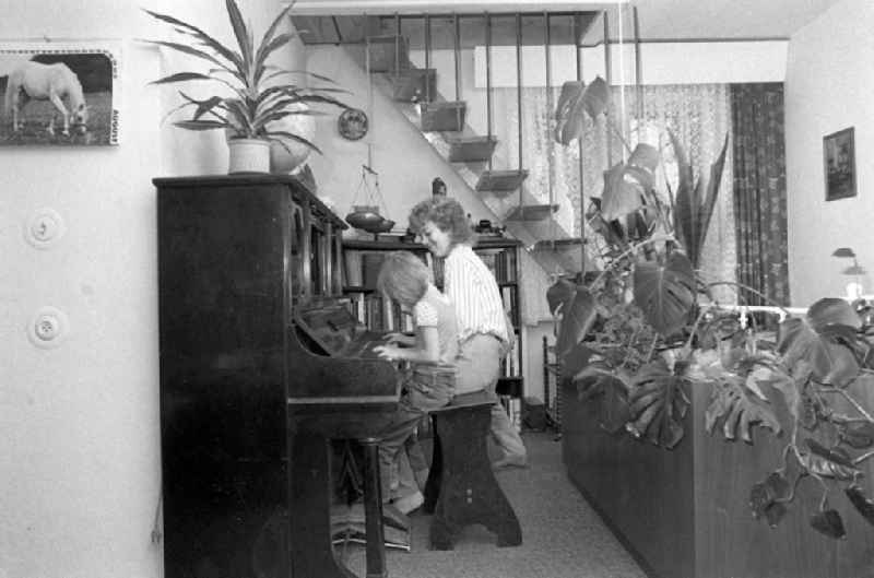 Child playing the piano and interior design of an apartment in Dresden in the state Saxony on the territory of the former GDR, German Democratic Republic