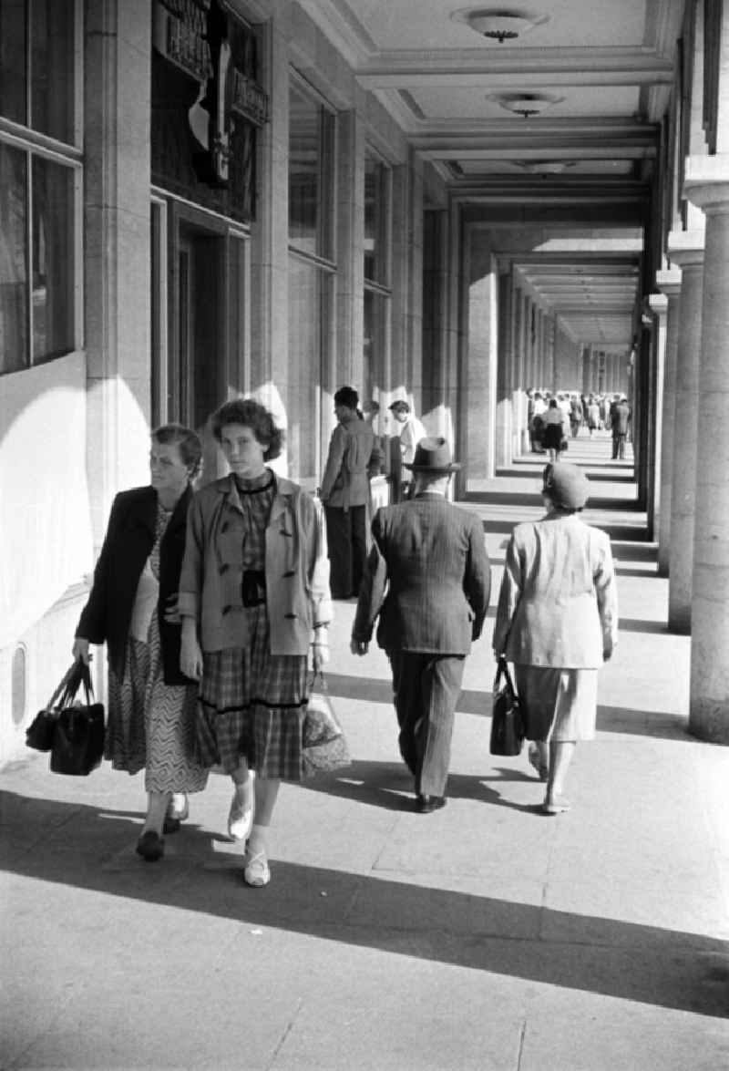Passanten schlendern durch den Säulengang des neuen HO-Warenhauses am Alten Markt in Dresden. 1952 wurde am Dresdner Altmarkt mit dem Aufbau des neuen Zentrums begonnen. Neben Ladenflächen und Wohnungen erhielt hier auch das in der DDR beliebte Café Prag sein zu Hause.