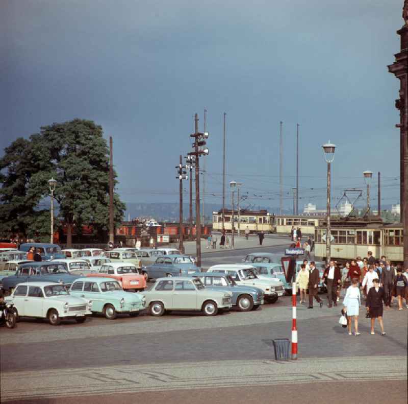 Passanten, Straßenbahnen und parkende Autos am Theaterplatz vor der Augustusbrücke in Dresden.