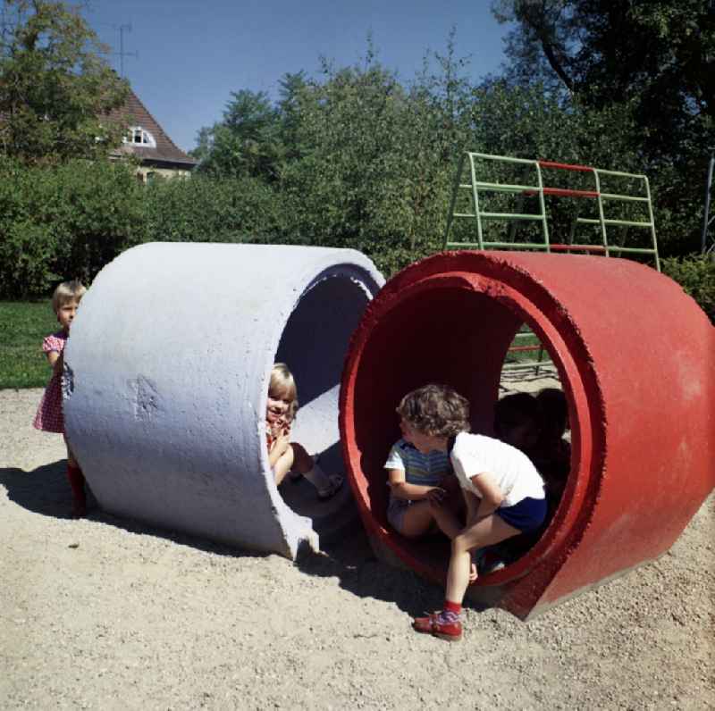 Children and young people in a playground of a kindergarten with colorful concrete elements in Dresden in the state Saxony on the territory of the former GDR, German Democratic Republic