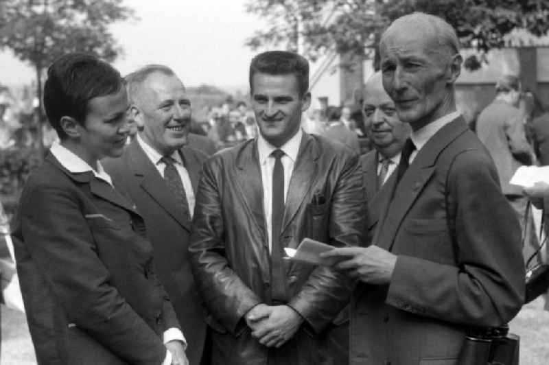 Dr. Guenter Gereke (right) talking to ski jumper Helmut Recknagel (second from right) and his wife Eva-Maria in Dresden in the state Saxony on the territory of the former GDR, German Democratic Republic