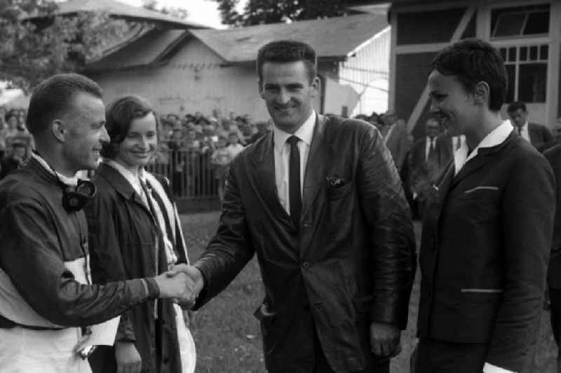 Ski jumper Helmut Recknage, next to Eva-Maria Recknagel (right), congratulates jockey Egon Czaplewski after the win in Dresden in the state Saxony on the territory of the former GDR, German Democratic Republic