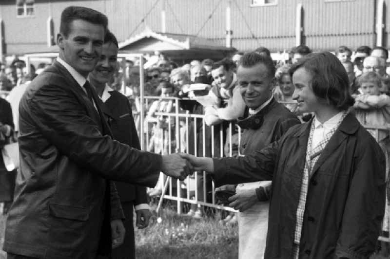 Ski jumper Helmut Recknagel congratulates racing rider Eva-Maria Dietrich after the victory in Dresden in the state Saxony on the territory of the former GDR, German Democratic Republic. Jockey Egon Czaplewski looks on